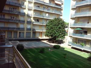 a large apartment building with a lawn in front of it at Apartamentos Montserrat in Blanes