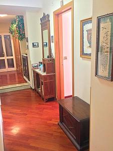B&B Gelone في سيراكوزا: غرفة معيشة مع أرضية خشبية وغرفة مع طاولة