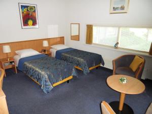 a hotel room with two beds and a table at Villa Voorncamp in Schoonhoven