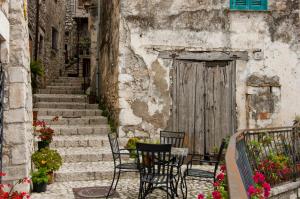 an alley with chairs and a wooden door at B&B Maison Civico 13 in Ausonia