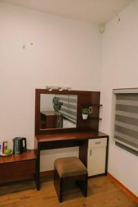 a desk with a mirror and a stool in a room at MAYA HOMESTAY villa in Hue