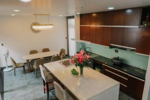 a kitchen with a table with a vase of flowers on it at MAY HOMESTAY Villa in Hue