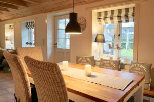 a dining room with a wooden table and chairs at Hygge in Boldixum +8 photos