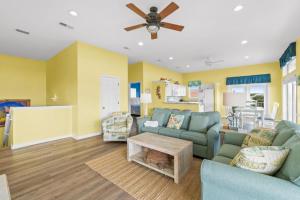 een woonkamer met een bank en een plafondventilator bij Dream Chaser-Private Pool-Pet Friendly-Directly across from boardwalk to beach in St. George Island