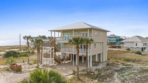 een huis aan het strand met palmbomen bij Dream Chaser-Private Pool-Pet Friendly-Directly across from boardwalk to beach in St. George Island