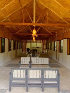 a large room with white benches in a building at Hill Myna Vacation House in Nagpoyopoyo Island
