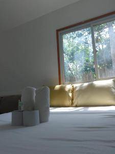 a room with a bed with a yellow blanket and a window at Hill Myna Vacation House in Nagpoyopoyo Island