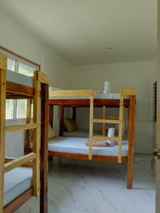 a room with three bunk beds in a room at Hill Myna Vacation House in Nagpoyopoyo Island