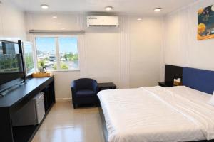 a bedroom with a bed and a chair and a television at Tâm Tín Hotel Hồ Chí Minh in Ho Chi Minh City