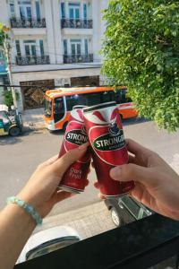 Een persoon die twee glazen frisdrank omhoog houdt. bij Tâm Tín Hotel Hồ Chí Minh in Ho Chi Minh-stad