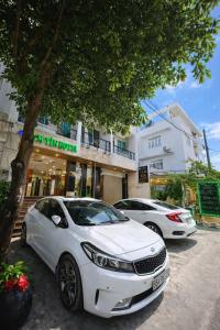 twee witte auto's geparkeerd voor een gebouw bij Tâm Tín Hotel Hồ Chí Minh in Ho Chi Minh-stad +53 foto's