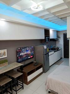 una cucina con tavolo e televisore di The Persimmon Mabolo Cebu City a Mabolo