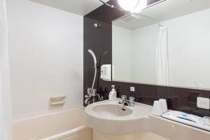 un bagno con lavandino e specchio di Comfort Hotel Kushiro a Kushiro
