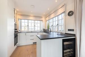 a kitchen with white cabinets and a black counter top at Hüs Amy in Rantum