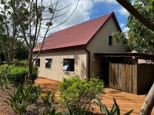una casa con tetto rosso e garage di Panache Wildlife Cottage-Self Catering a Hoedspruit