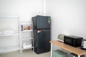 a black refrigerator in a room with a desk at The Rock Coco Villa 2 in Ban Sai Mat