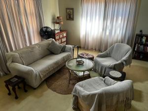 a living room with a couch and two chairs and a table at Panache Wildlife Cottage-Self Catering in Hoedspruit