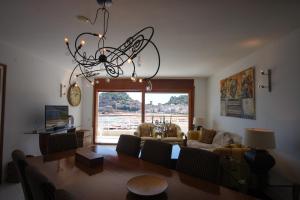 a living room with a dining table and a chandelier at Lets Holidays Tossa de Mar Beach Apartment in Tossa de Mar