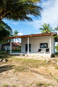 a white house with palm trees in front of it at The Rock Coco Villa in Ban Laem Pom