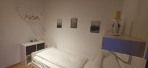 een witte kamer met een witte bank en een blauwe tafel bij Quartier132 in Öfingen