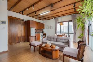 a living room with a couch and a table at XÔI Sakamoto 2 Suites Kim Ma in Hanoi