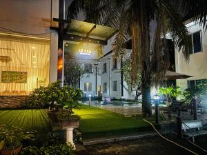 a courtyard of a building with a palm tree at Orova Hotel in Ấp Phú Thọ