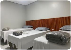 een kamer met drie bedden in een kamer bij Hotel Bueno's - Francisco Beltrão in Francisco Beltrão