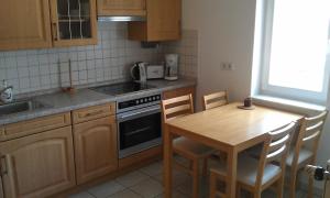 a kitchen with a table and a sink and a stove at Appartements Am Theater in Weimar