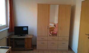 a bedroom with a cabinet with a computer on a desk at Appartements Am Theater in Weimar