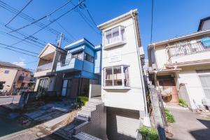 a white and blue house on a street at Hotel Emile102 in Tachikawa