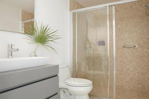 een badkamer met een douche, een toilet en een wastafel bij Radisson Blu Aruba in Palm-Eagle Beach