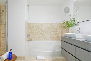 een witte badkamer met een bad en een wastafel bij Radisson Blu Aruba in Palm-Eagle Beach +173 foto's