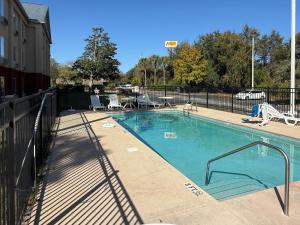 einen Pool mit Stühlen und einem Zaun in der Unterkunft Quality Inn Ormond Beach - Daytona in Ormond Beach
