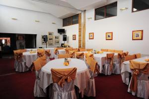 a banquet hall with tables and chairs in a room at Hotel Gorj in Târgu Jiu