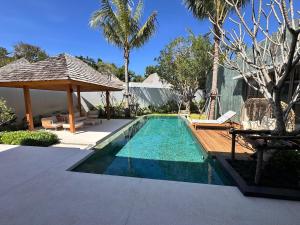 a swimming pool in a backyard with a gazebo at Anchan Flora Luxury 2BR Pool Villa in Thalang
