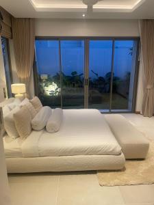 a white bed in a room with a large window at Anchan Flora Luxury 2BR Pool Villa in Thalang +73 photos