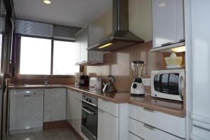 a kitchen with white cabinets and a microwave at La Nogalera 7 in Torremolinos