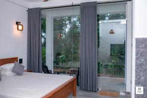 a bedroom with a bed and sliding glass doors at Willow Waters in Galle