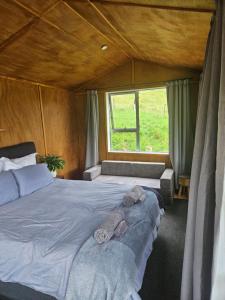 een slaapkamer met een bed met twee knuffels erop bij Mahakipaoa Cabin in Linkwater