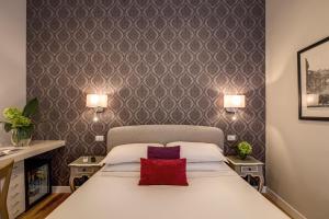a bedroom with a white bed with a red pillow at The Club Navona in Rome