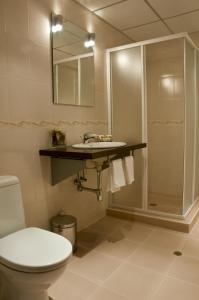 a bathroom with a toilet and a sink and a shower at Hotel 4 Zona in Sofia