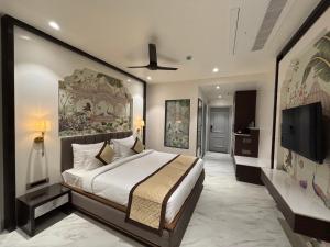 a bedroom with a large bed and a flat screen tv at Hotel Raj Hari Palace in Jodhpur