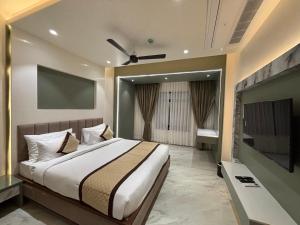 a bedroom with a bed and a flat screen tv at Hotel Raj Hari Palace in Jodhpur