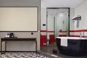 een badkamer met een bad en een douche bij Meisu Hotel in Changsha +8 foto's