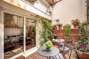 un patio al aire libre con mesas, sillas y plantas en Magenta Collection Navona en Roma
