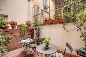 a patio with two tables and chairs and plants at The Club Navona in Rome