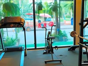 een fitnessruimte met uitzicht op een zwembad bij Chinawat Hotel in Sukhothai