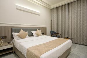 a hotel room with a large bed and a chair at The Grand Platinum Hotel in Ahmedabad +74 photos