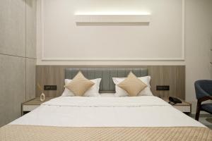 a bedroom with a large bed with white sheets and pillows at The Grand Platinum Hotel in Ahmedabad