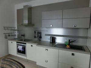 a kitchen with white cabinets and a sink at Ferienwohnung in Lobau in Vienna